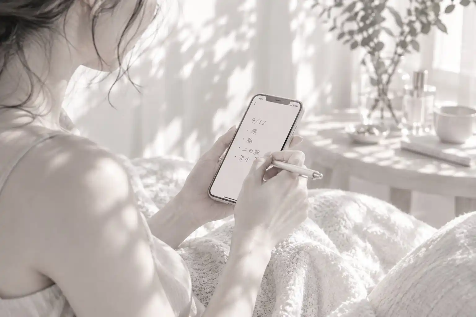 スマートフォンのメモに日付と部位を記録している手元（イメージ）